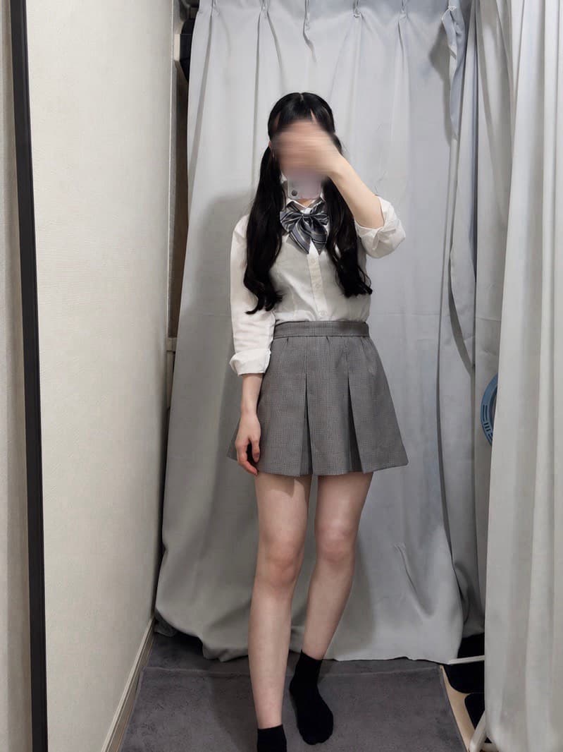 みくり(7/23体験入店🔰)が白シャツとスカートを着てポーズをとる。
