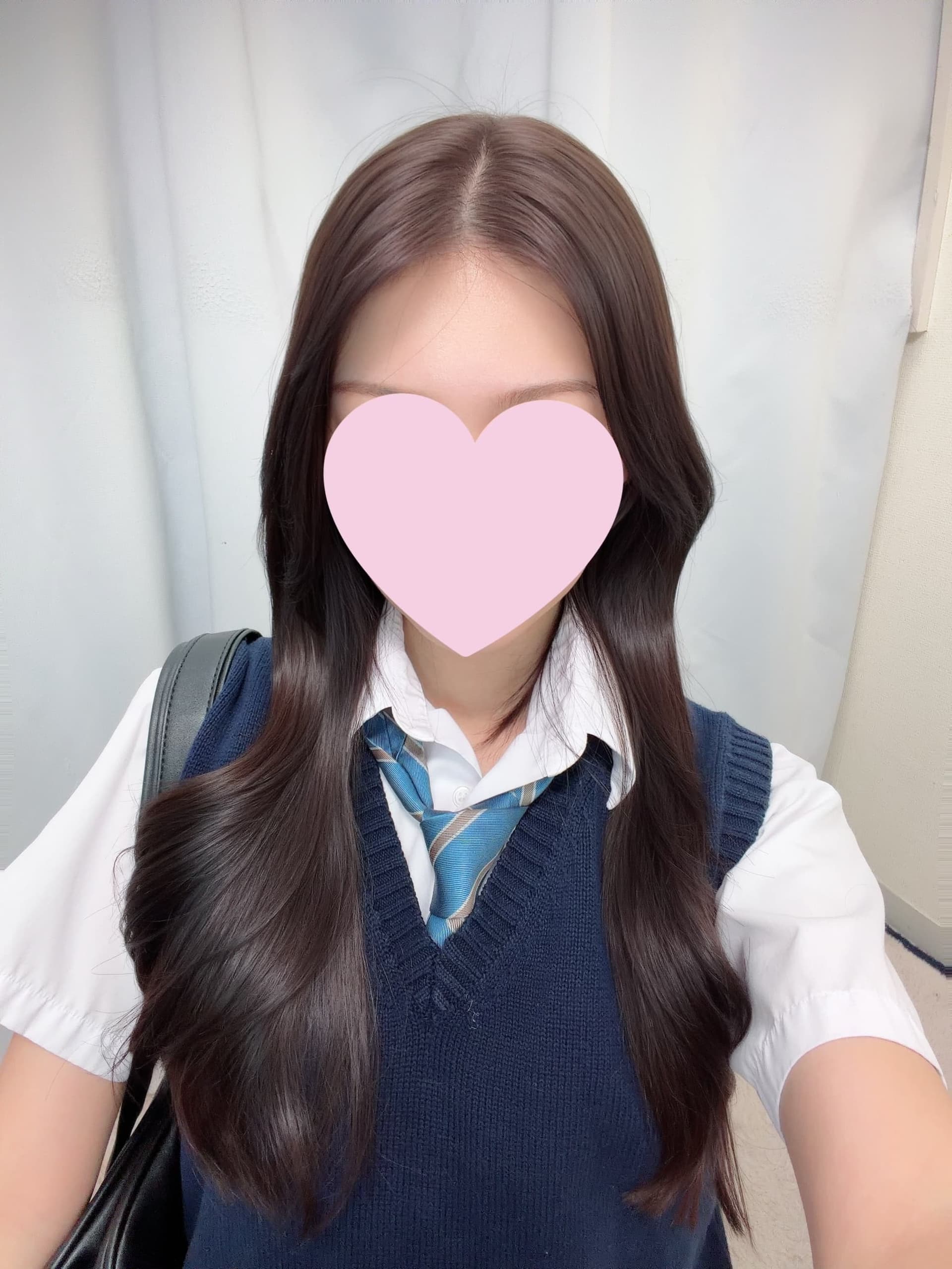 みこ(JK上がりたて18歳)、制服姿で微笑む自撮り。背景は無地の白。