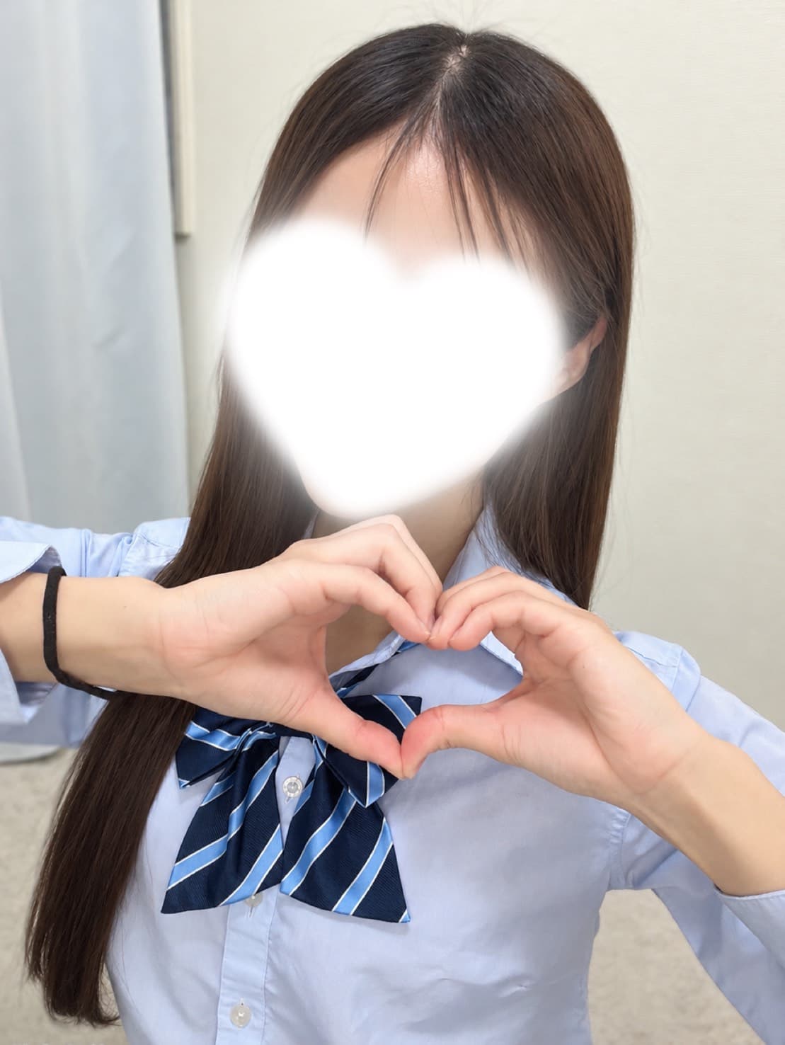 なな🔰10/23体験入店初日🔰が青いシャツで笑顔でハートを作っている。