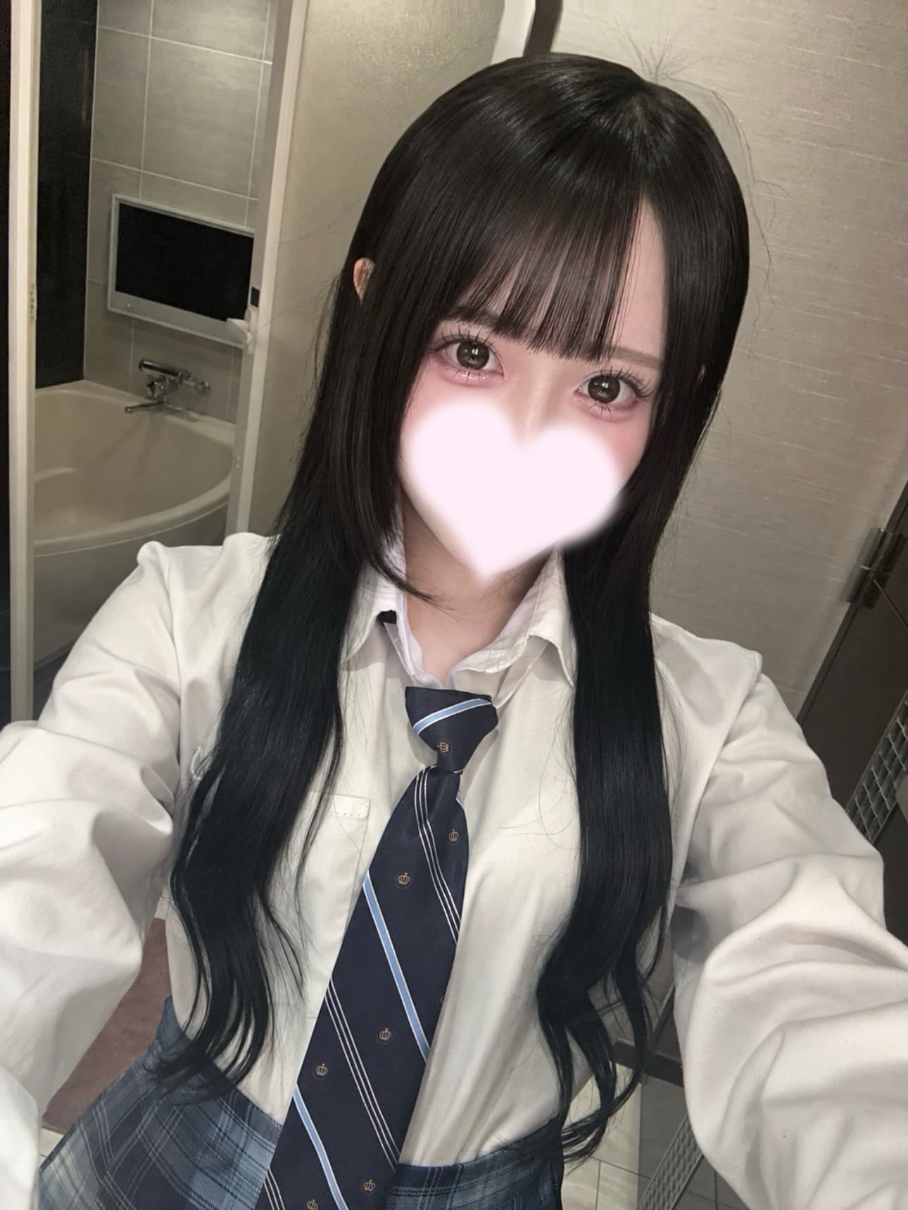 ことこが制服を着て微笑む、自撮り風の画像。背景は浴室。