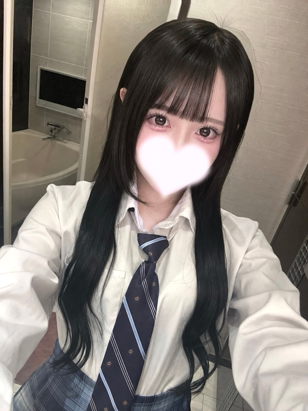 ことこは白いシャツとネクタイ、スカート姿で自撮り中。背景は洗面所。
