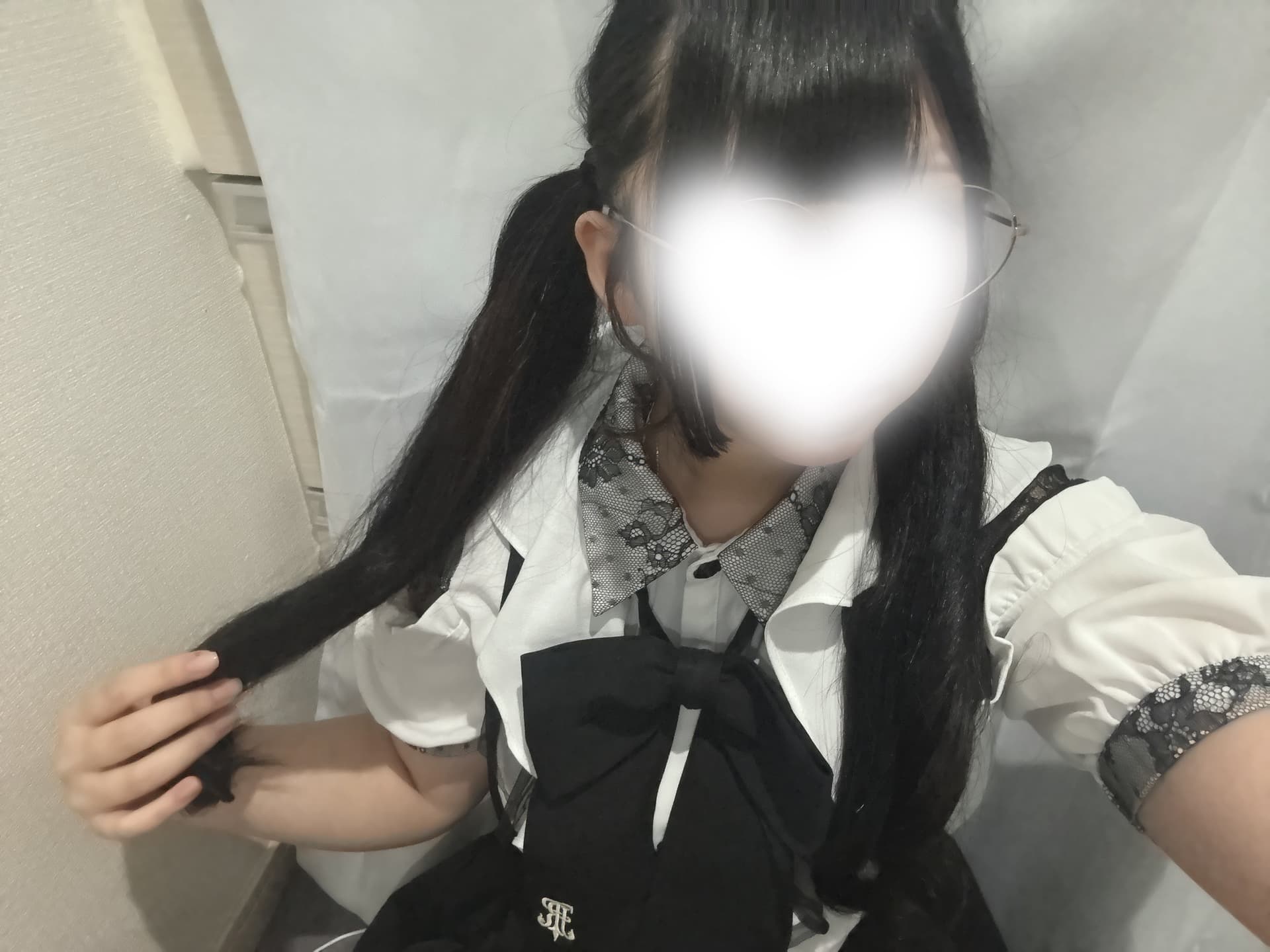 ゆいのは白いブラウスと黒いスカートを着て微笑んでいる。