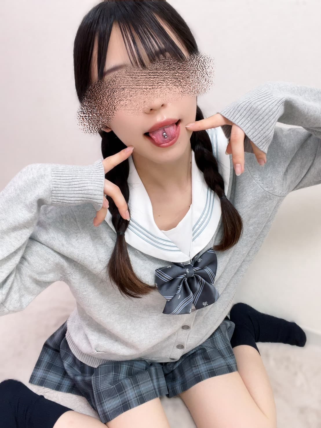 さゆのが微笑みながらピースサインをする制服姿の写真。