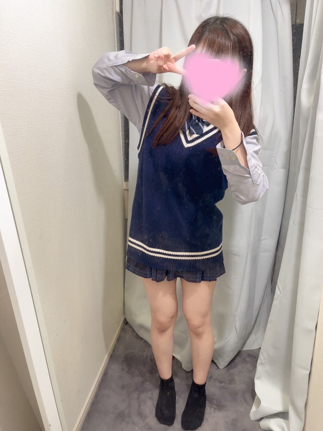 みはるがセーラー服を着て笑顔でピースサインをしている。