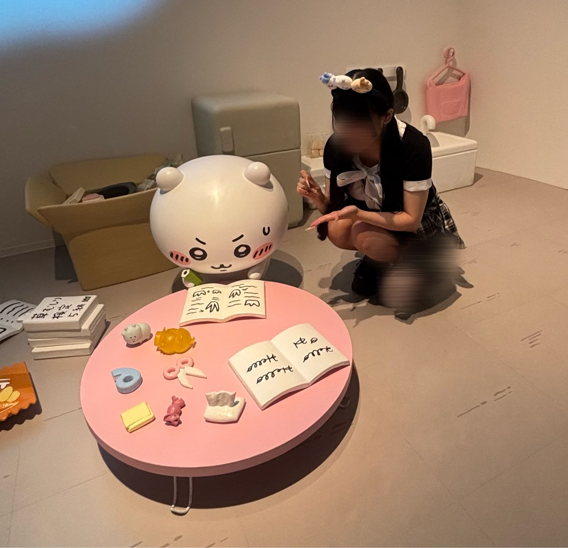 さきが可愛い服装でテーブルの前にひざまずき、楽しそうに遊んでいる。