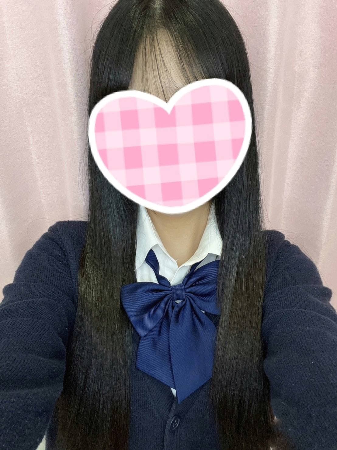 いちのはセーラー服を着て微笑み、背景はピンクのカーテン。