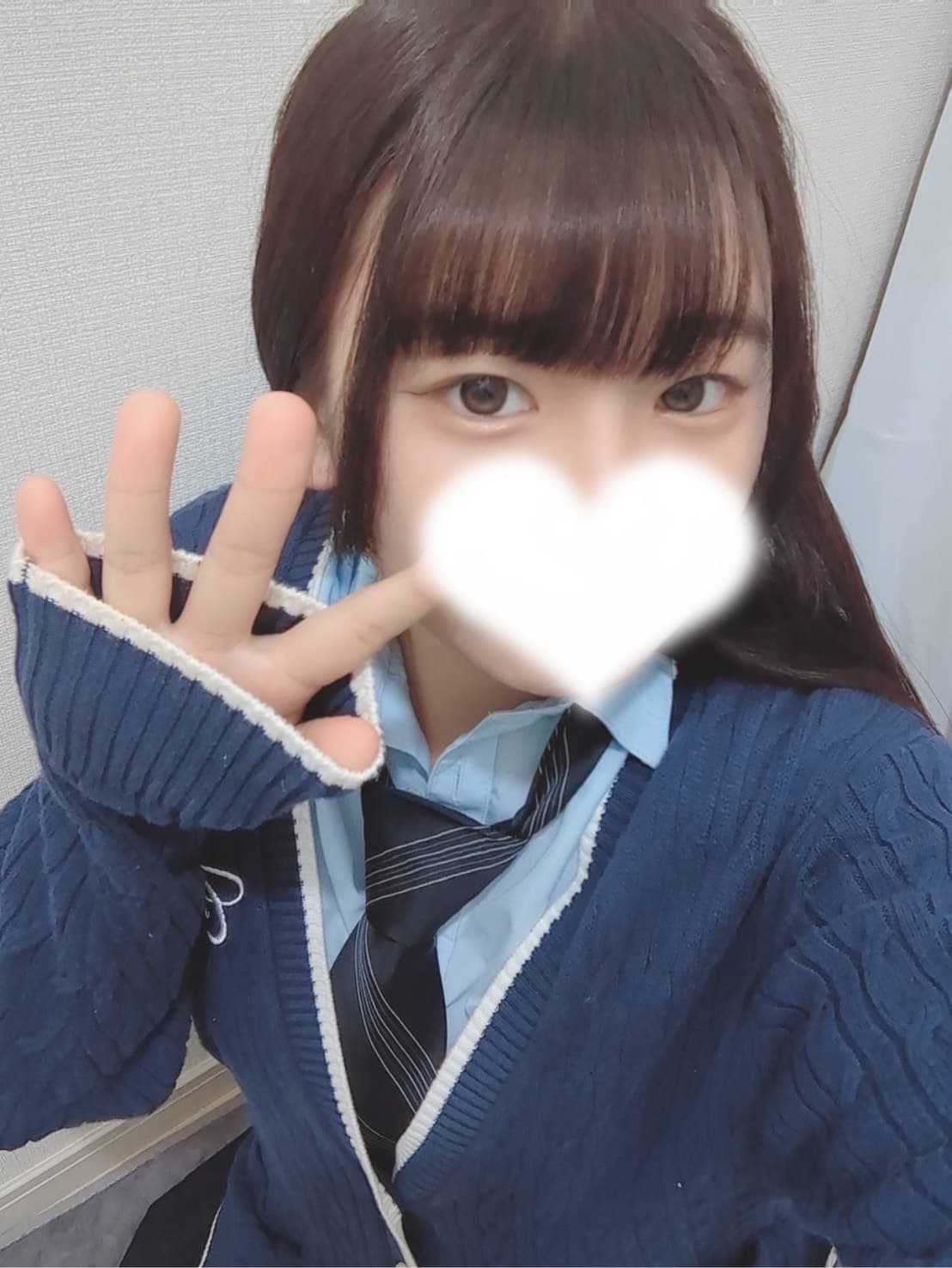 ちせが青いセーターを着て笑顔でピースサインをしている。