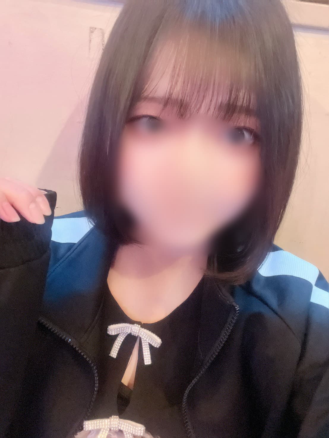 まなつはカジュアルな服装で微笑み、明るい背景に映えている。