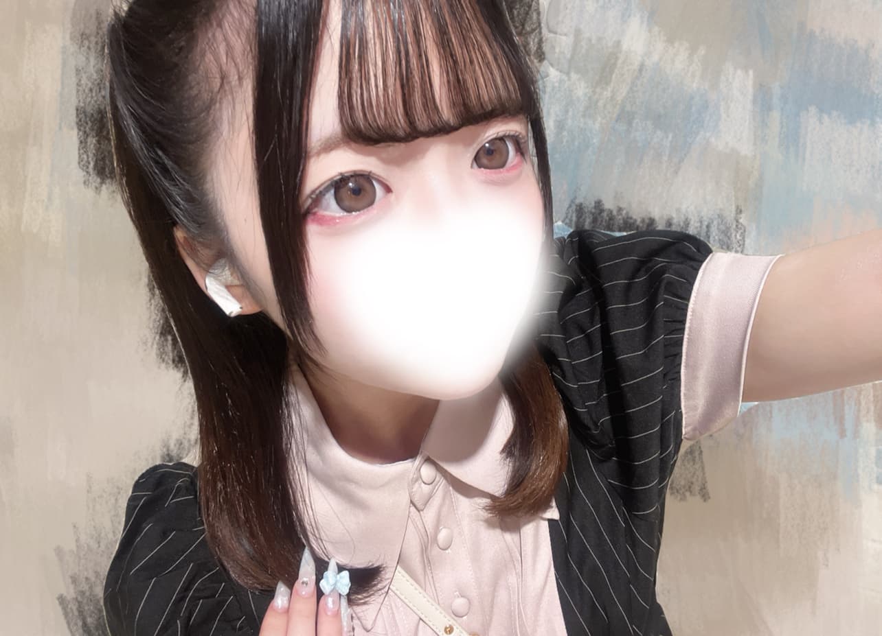 あおいは黒と白のストライプの服を着て笑顔でポーズを取っている。