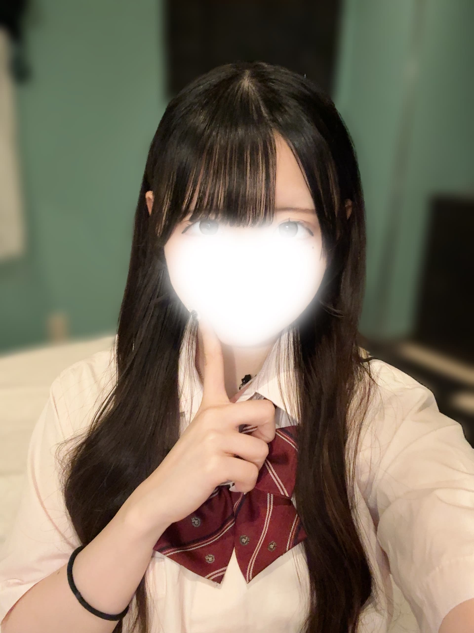 みみ🔰(JK上がりたて18歳)が白い背景で指を口元に当てて微笑んでいる。