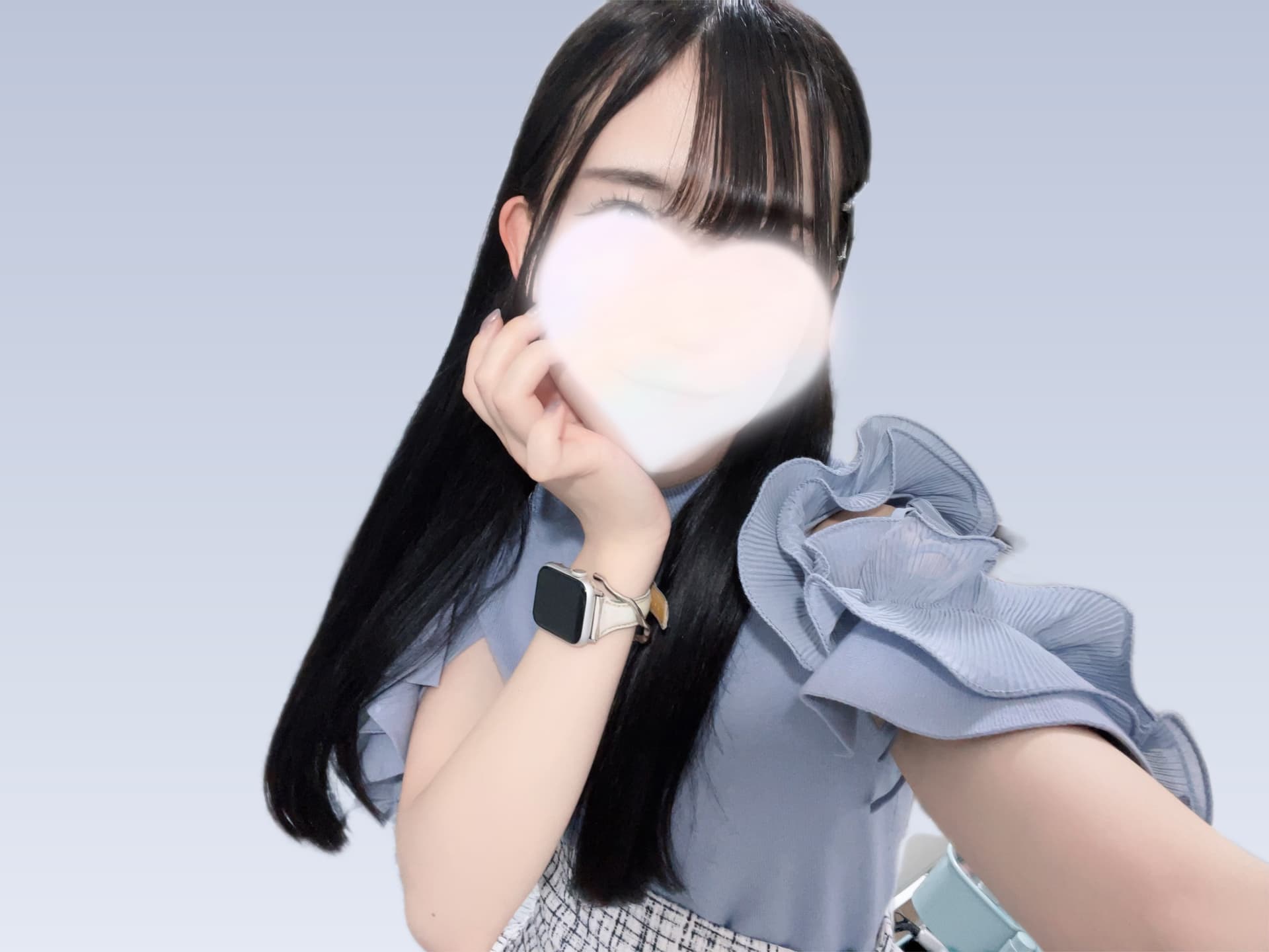 さゆのが青いトップスを着て微笑みながらポーズをとっている。