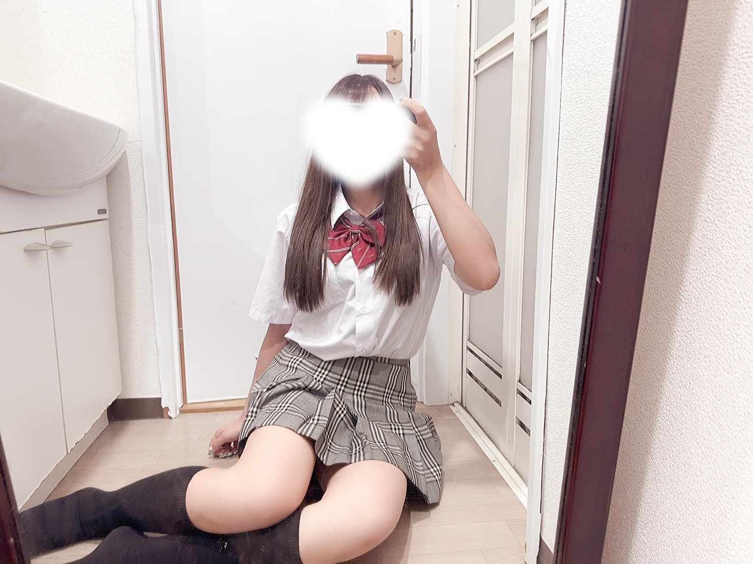 あずきが制服姿で微笑み、鏡の前に座っている。