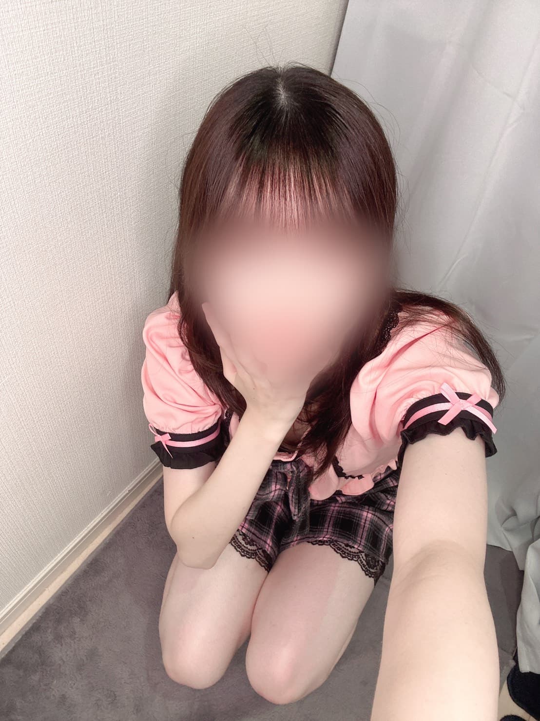 ひめめ(7/3体験入店🔰)、ピンクの服を着て控えめな表情。背景はシンプル。