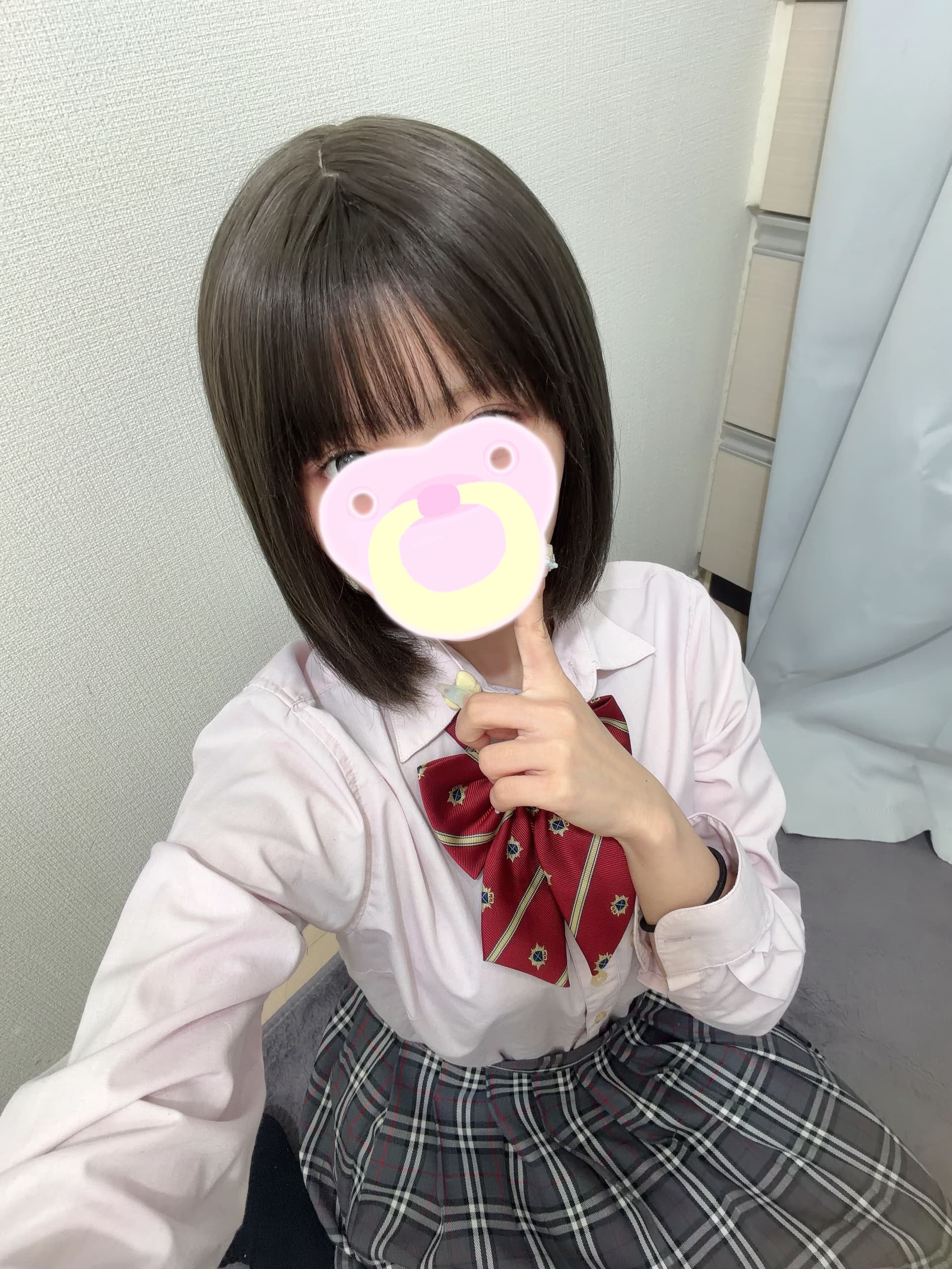 こるね 9/11体験入店初日🔰JK上がりたて18才✨制服姿で微笑みながら指を口元に持つ。