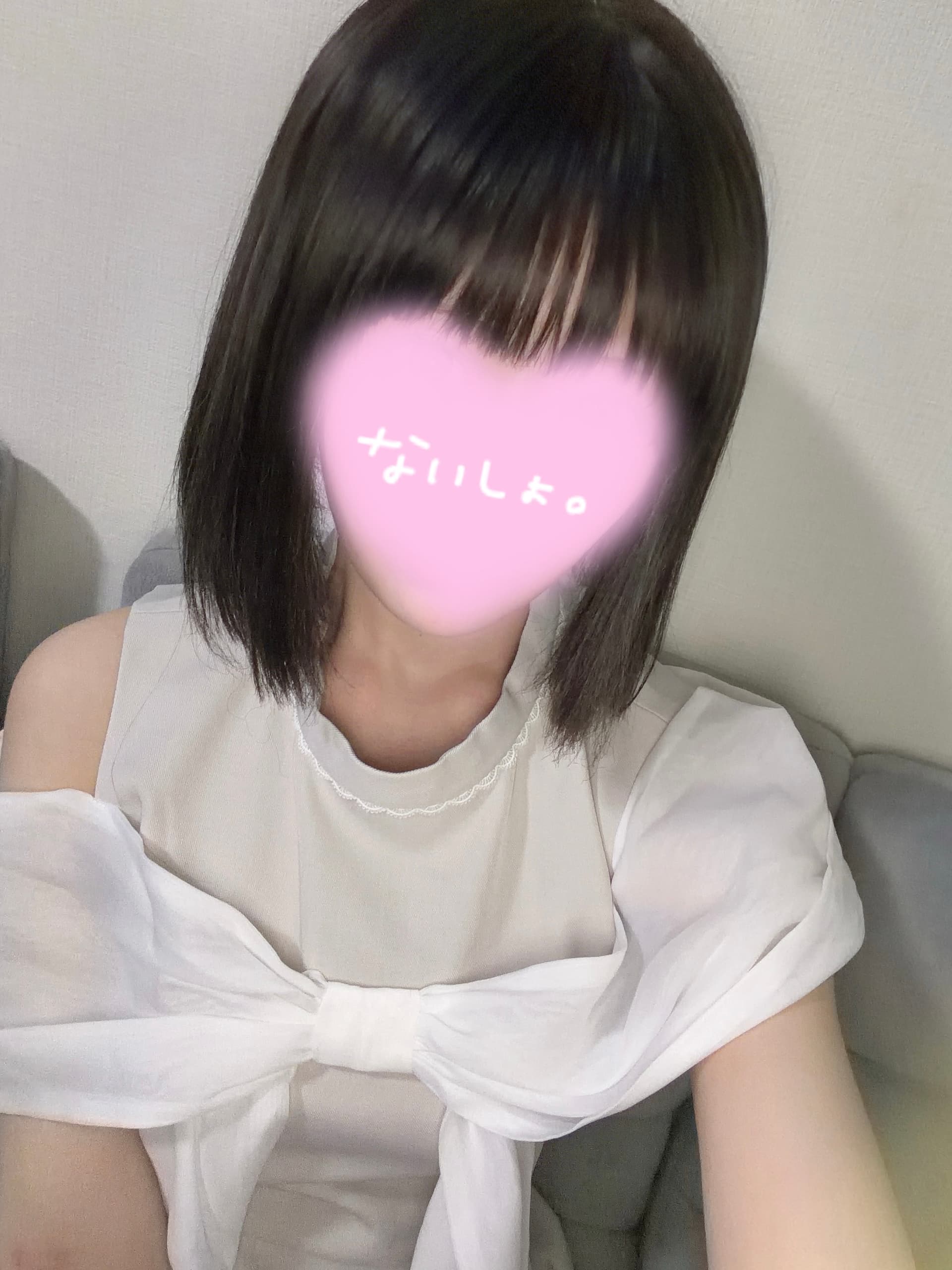 こるねさんは白い服を着て微笑みながらカメラを見つめています。