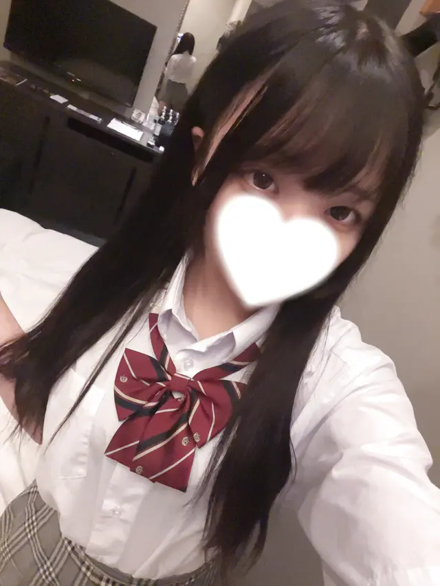 さらが制服を着て微笑む様子、背景には家具が見える。
