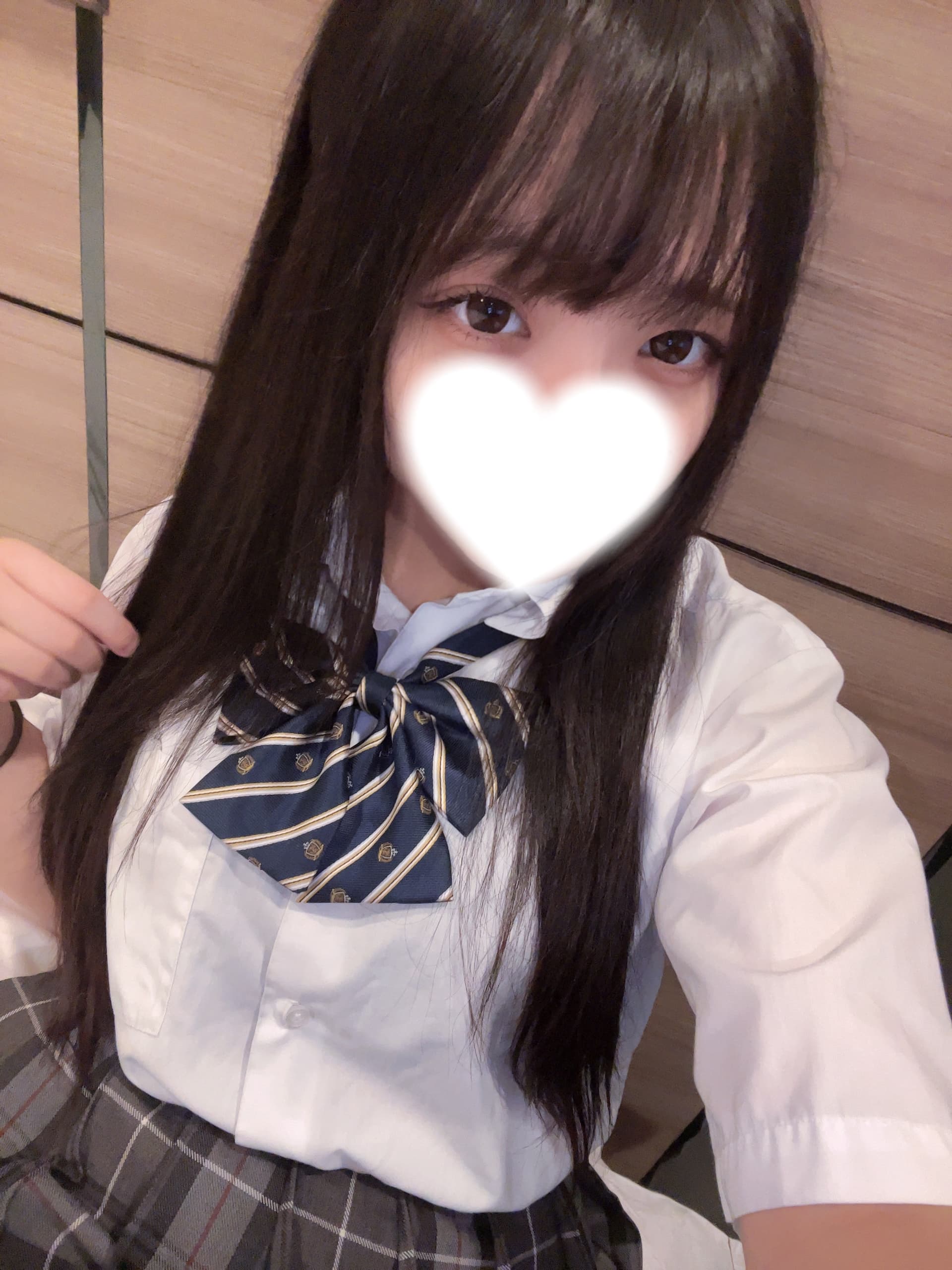 さらが制服を着て微笑んでいるセルフィー。背景は木目調の壁。