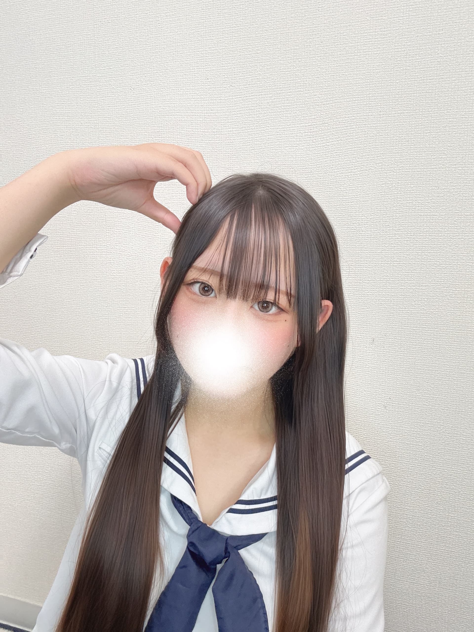 このがセーラー服を着て、微笑みながらポーズを取っている。